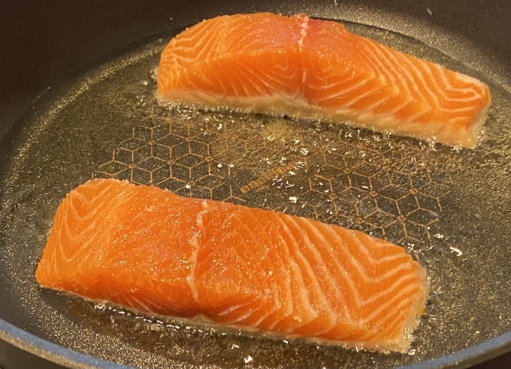 raw salmon in frypan