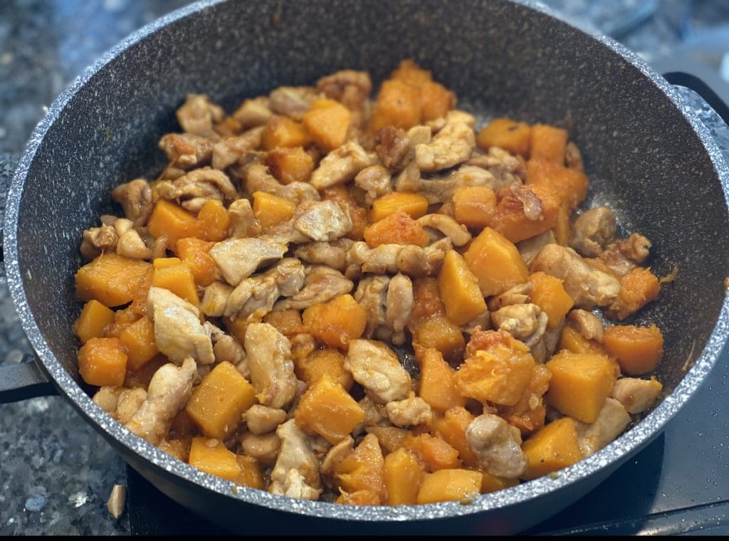 adding pumpkin and sauce to the chicken