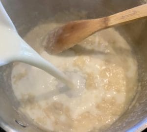 Adding milk into the pan to make a creamy sauce