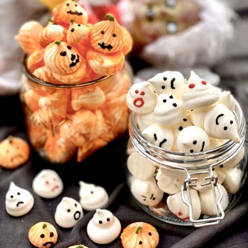 Halloween meringue cookies in glass jars featuring ghost and pumpkin shaped meringues