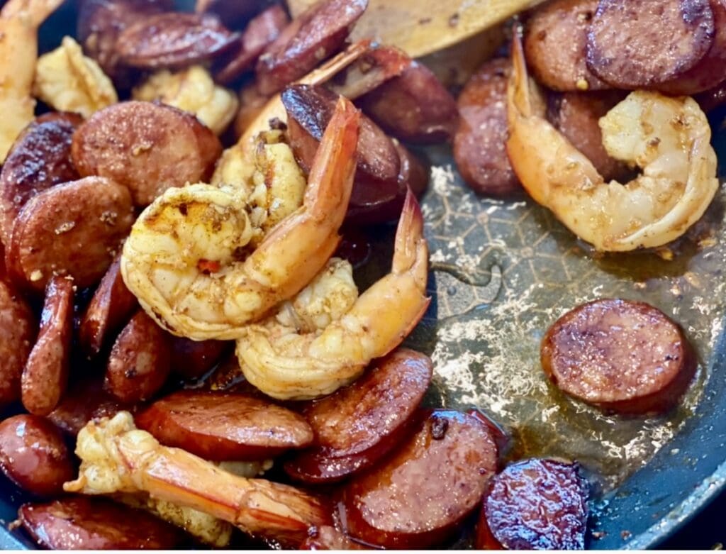 Prawns and sliced chorizo frying in garlic oil in a pan