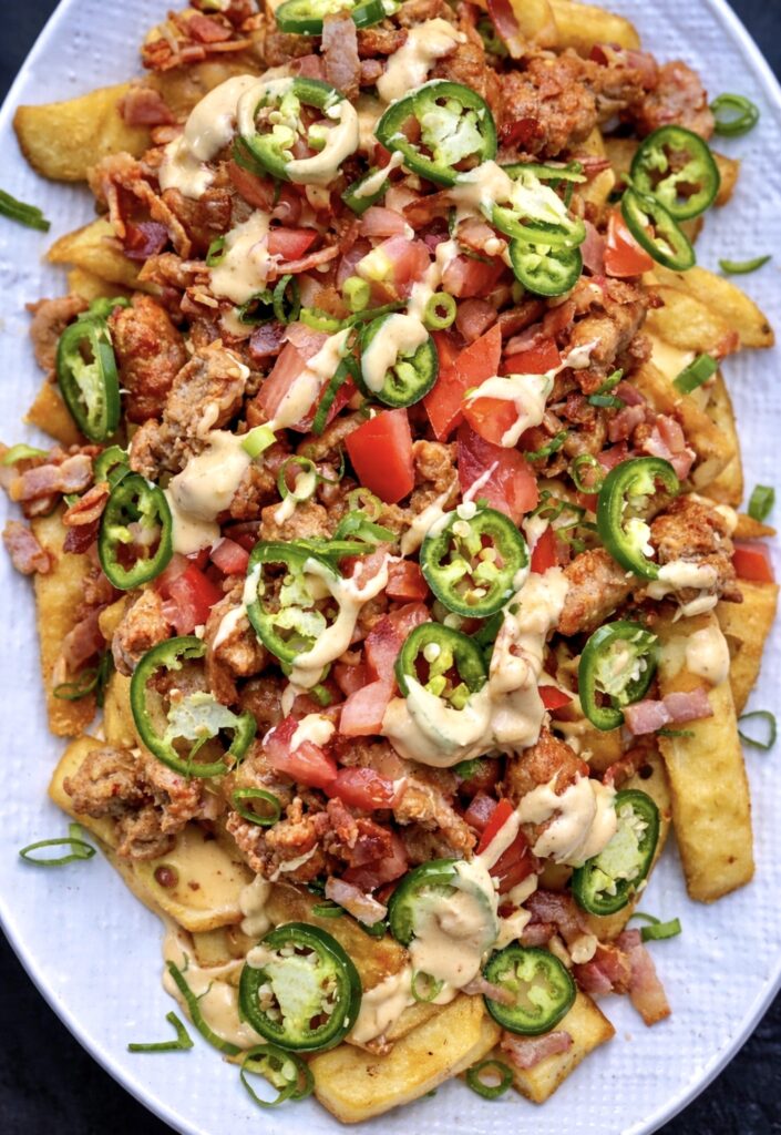 Loaded fries topped with sausage, bacon, jalapeños, diced tomatoes and creamy cheesy sauce.