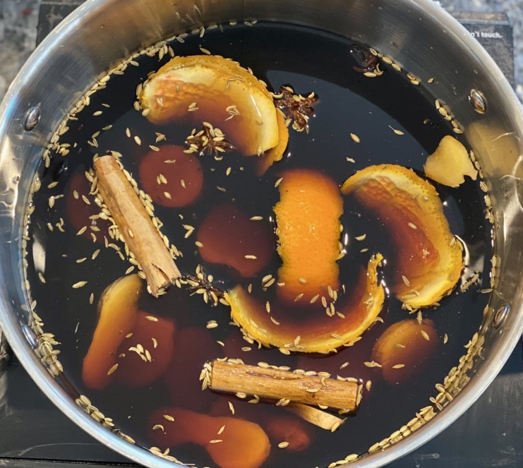 Orange peel, cinnamon stick and soy sauce in a saucepan for the salmon masterstock broth