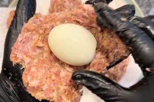 wrapping sausage around egg