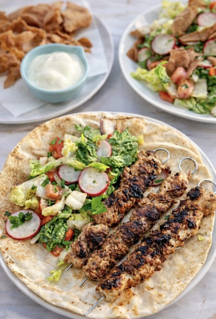 Middle Eastern shish tawook chicken skewers with lettuce, radish salad and flatbread