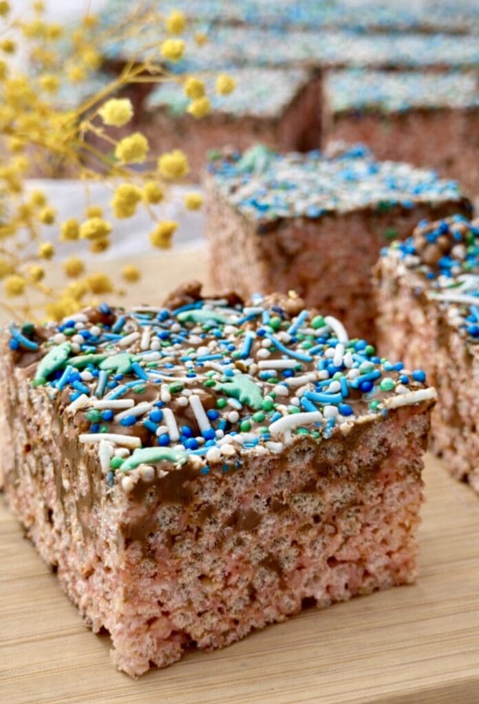 Homemade rice bubble slice with brown butter and chocolate, cut into squares on a wooden board.