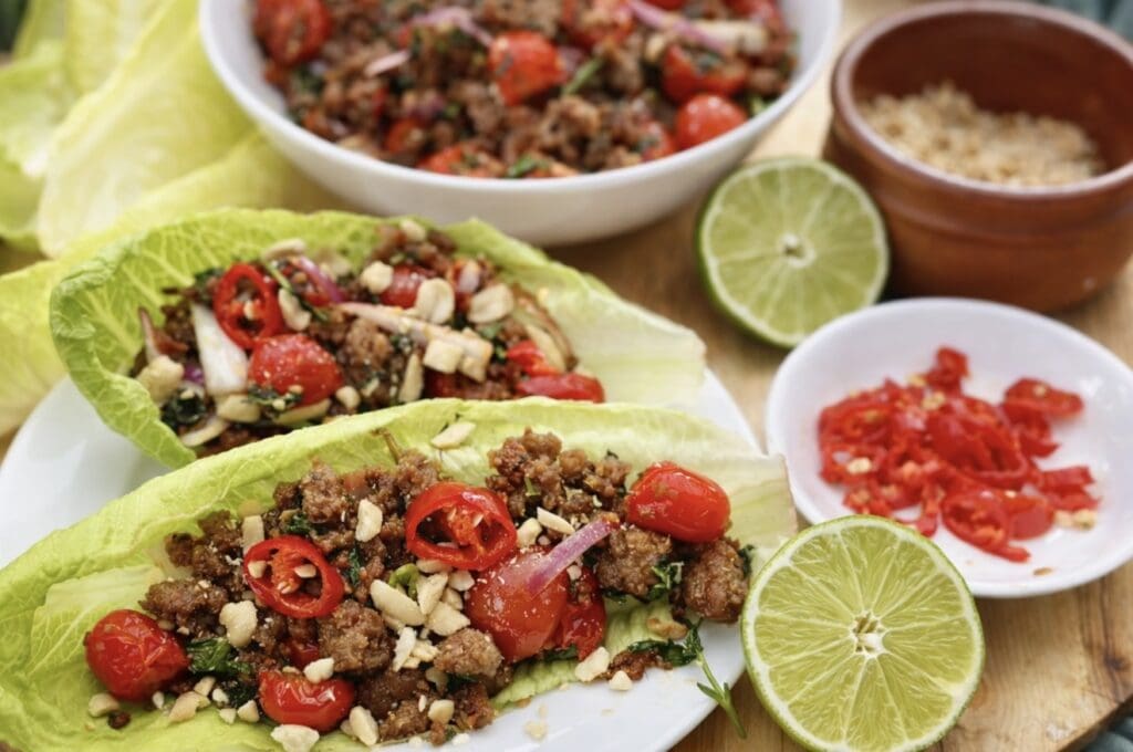 Cripsy pork mince served in vibrant crisp green lettuce leaves, served with lime, roasted peanuts and sliced chillies