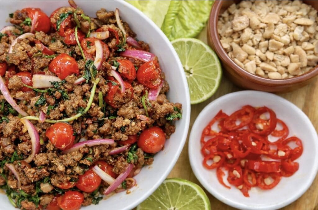 A top view of pork mince, chillies, limes, lettuce and peanuts, ready to be made into Asian Lettuce Cups