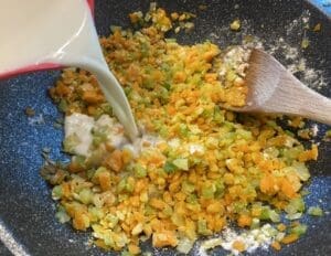 Poaching milk being poured into the pan to create a creamy white sauce