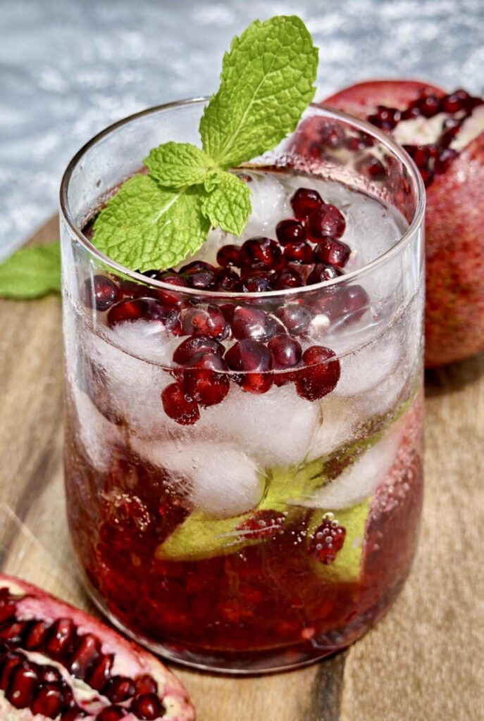 Festive pomegranate cocktail in a glass with fresh pomegranate and citrus
