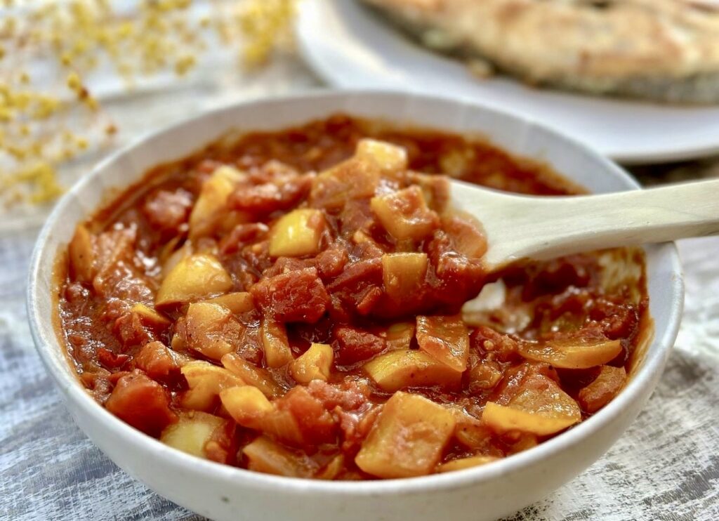 Homemade tomato sauce simmering with onions for fish in tomato sauce dinner