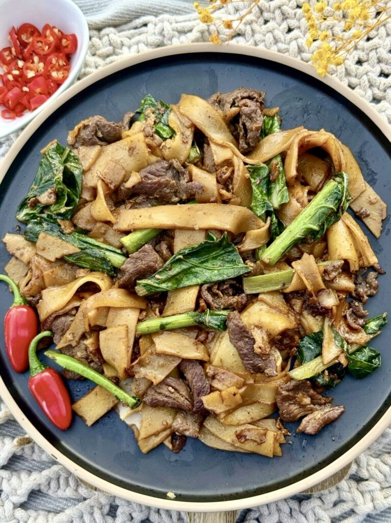 Thai pad see ew made with chewy flat rice noodles, sliced beef and crisp gai lan, finished with a rich savoury sauce