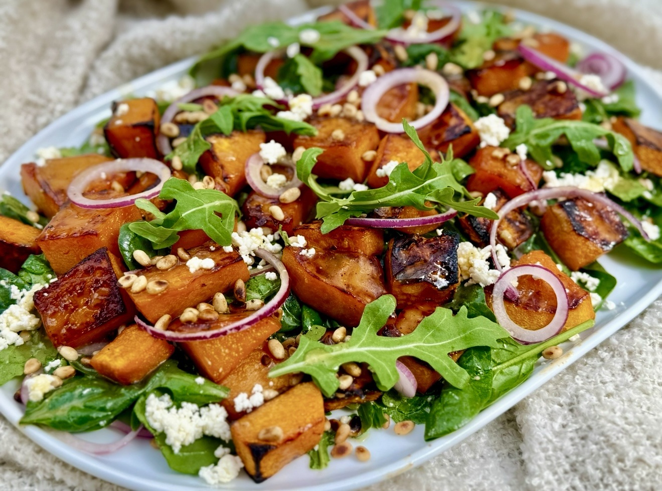 Honey roast pumpkin salad with baby spinach feta and pine nuts