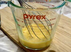 Beating the eggs in jug with a whisk