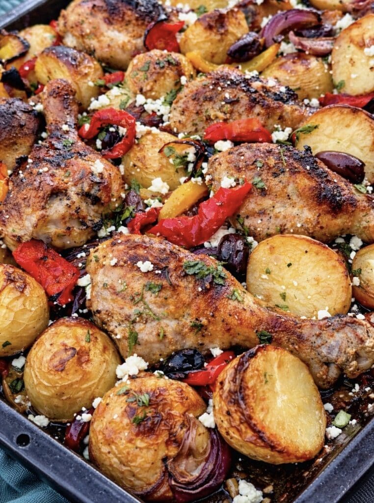 Juicy Greek sheet pan chicken and crispy roasted potatoes with lemon, oregano, vegetables and feta