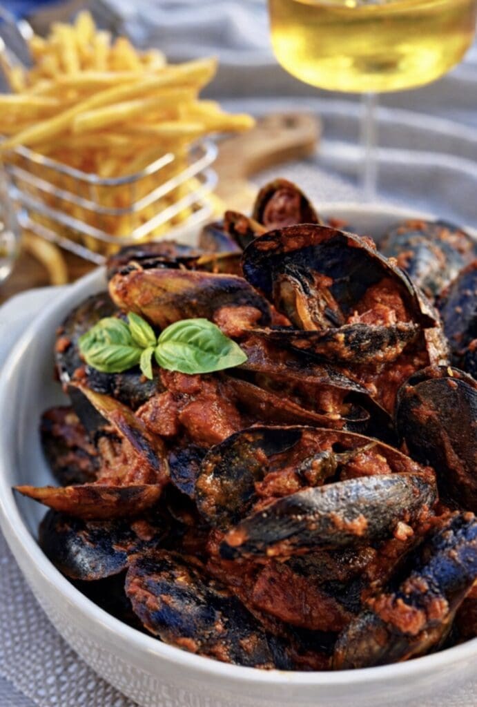 Spicy tomato mussels with chorizo topped with fresh basil