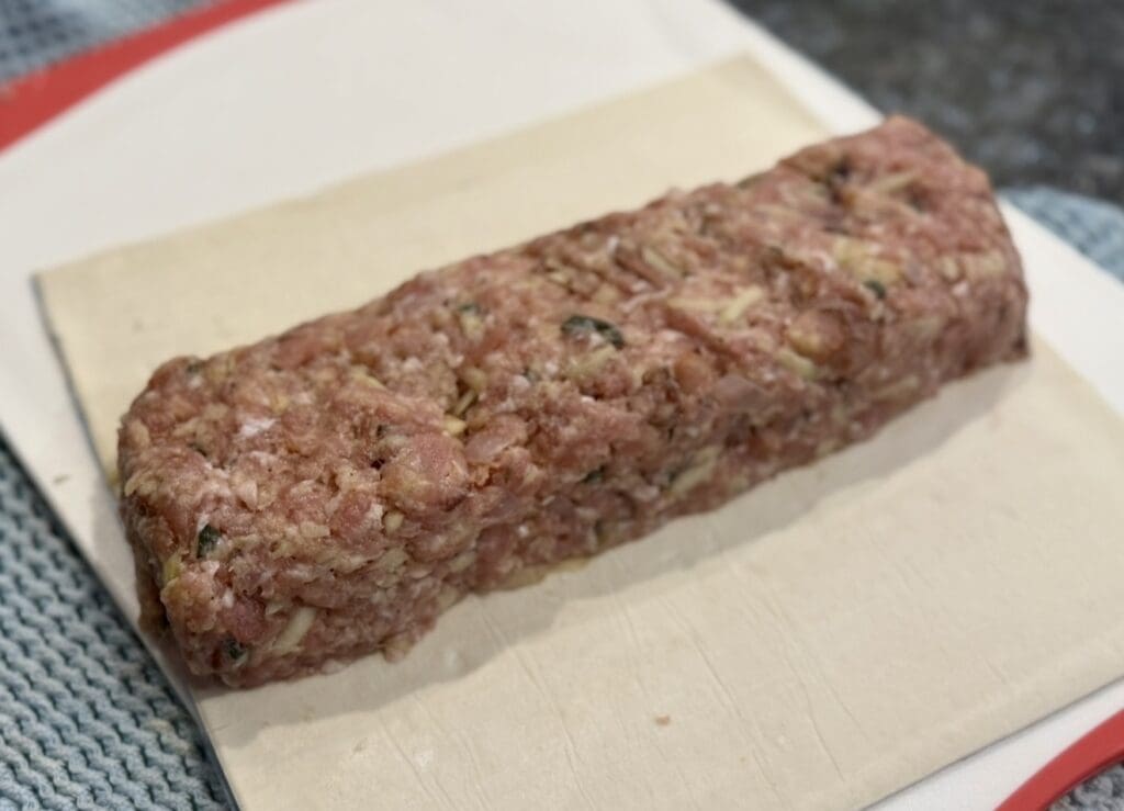 Creating a log or rectangle with a filling inside a puff pastry sheet.