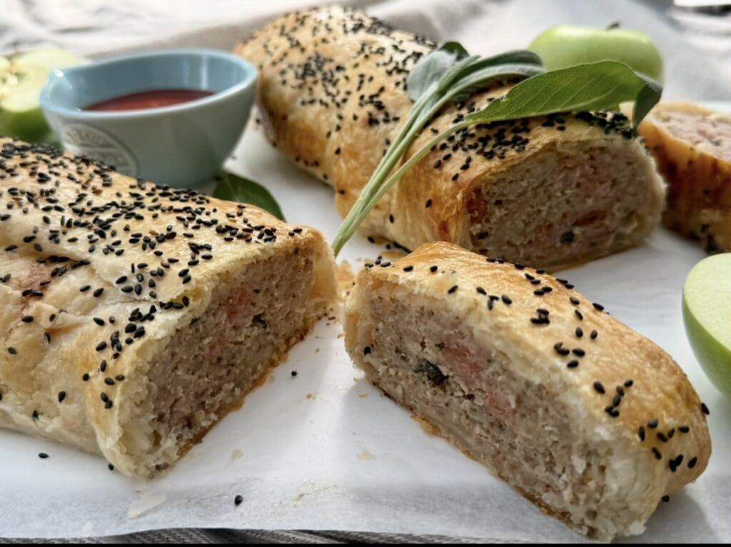 A photo zooms in on pork and apple sausage rolls, highlighting the filling and bacon.