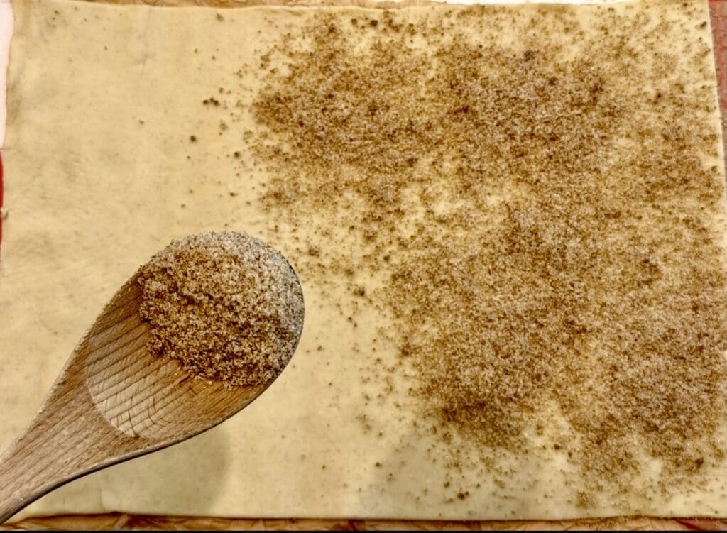 Sprinkling the sugar over the puff pastry sheet