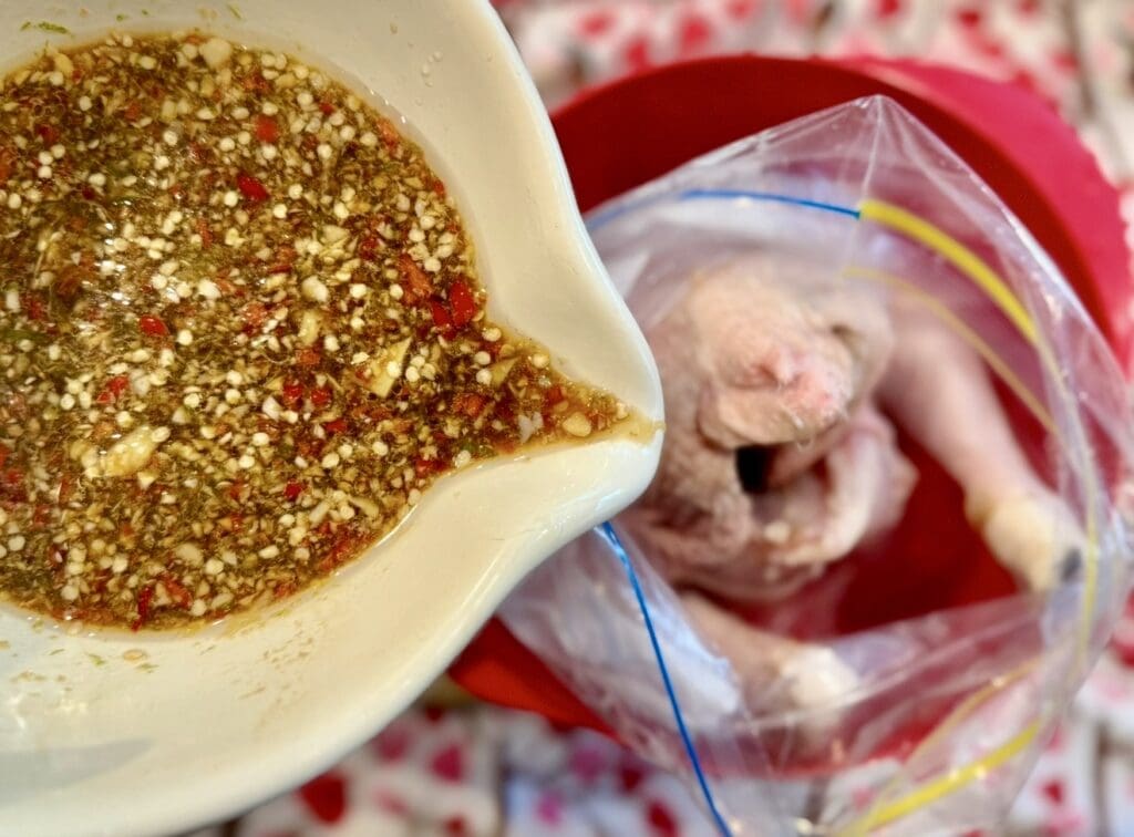 Pouring the marinade into a bag with the chicken in it