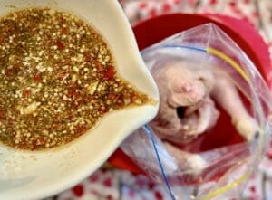 Pouring the marinade into a bag with the chicken in it