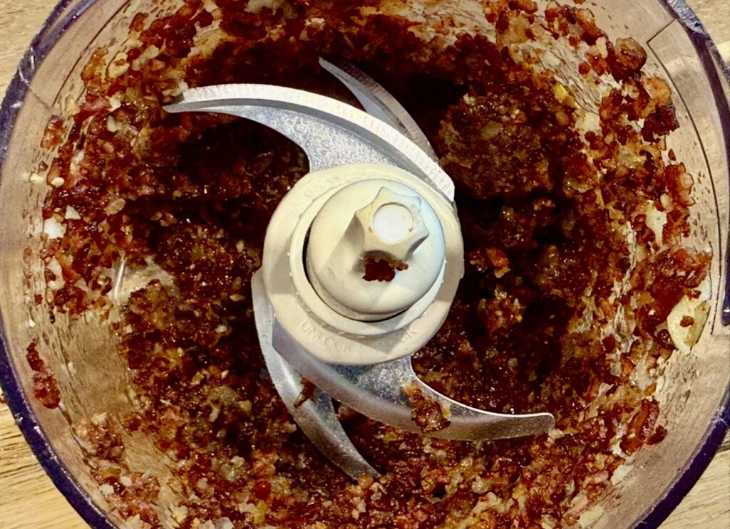 Blended bacon and onion mixture in a food processor for rich homemade bacon dip