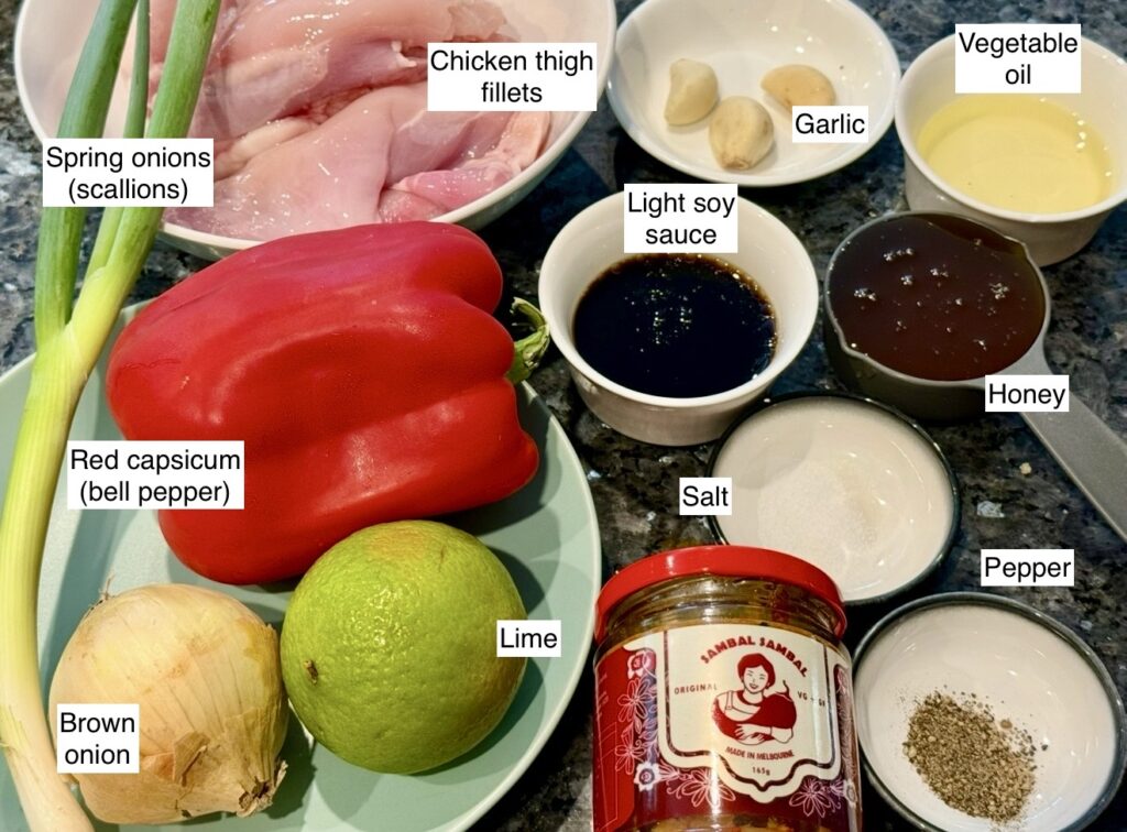 Ingredients for honey sambal chicken laid out, including chicken, sambal, honey, soy sauce, lime and capsicum