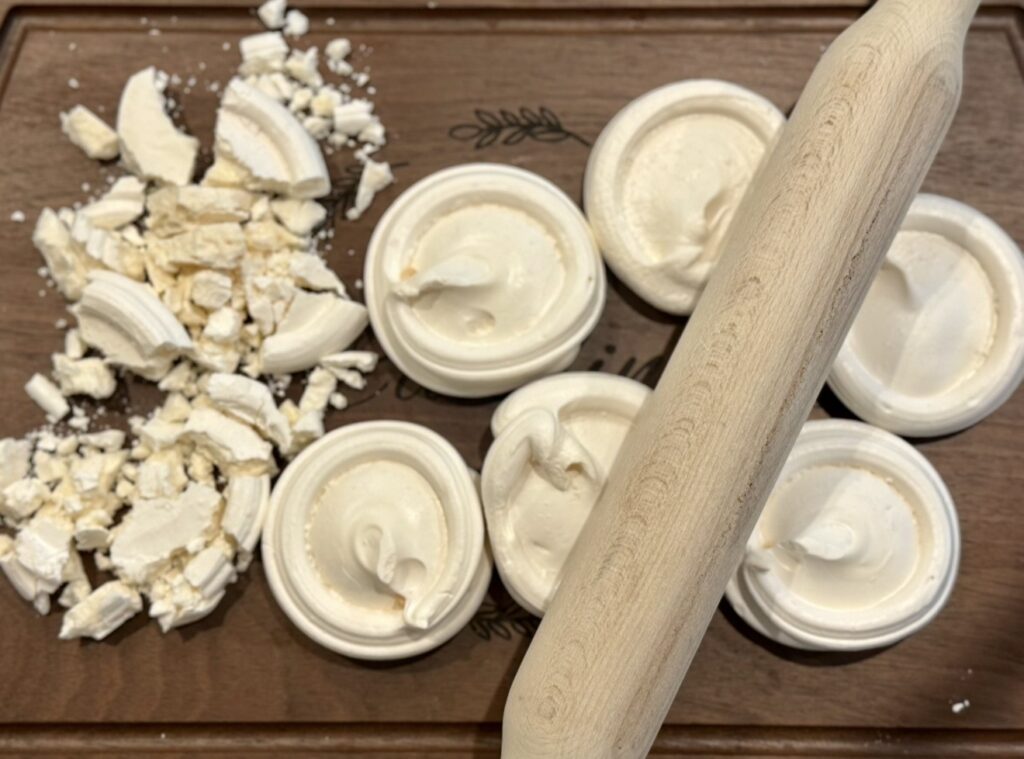 Crushing the meringues into small pieces using a rolling pin
