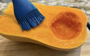 How to make homemade pumpkin purée – brushing pumpkin with oil before roasting in the oven